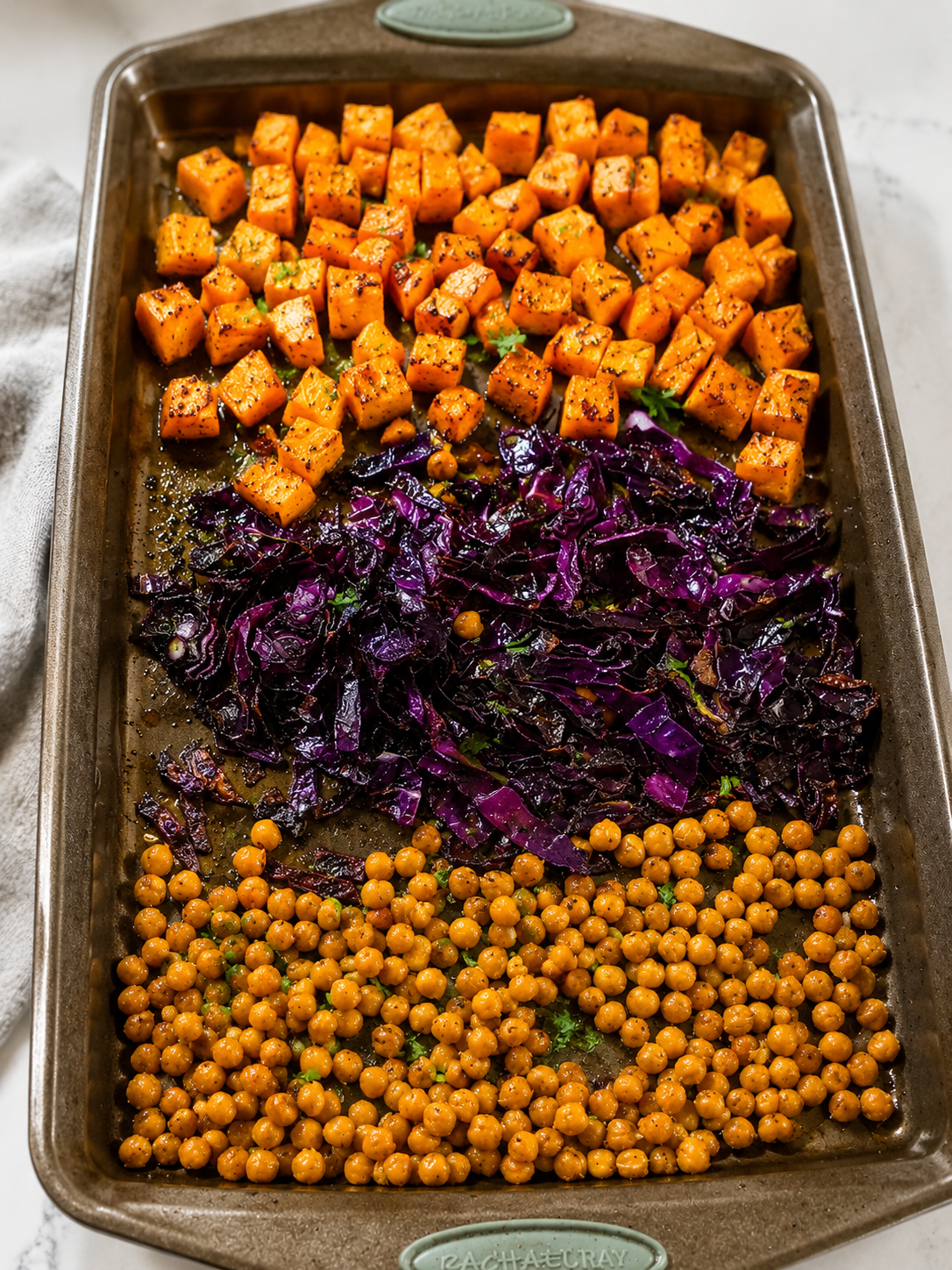 Sheet pan with roasted curried sweet potatoes, red cabbage, and chickpeas fresh from the oven