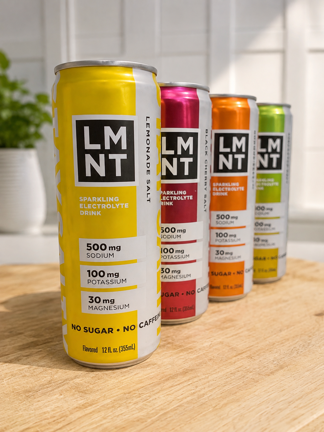 LMNT Sparkling Electrolyte Drink cans lined up on a wood countertop